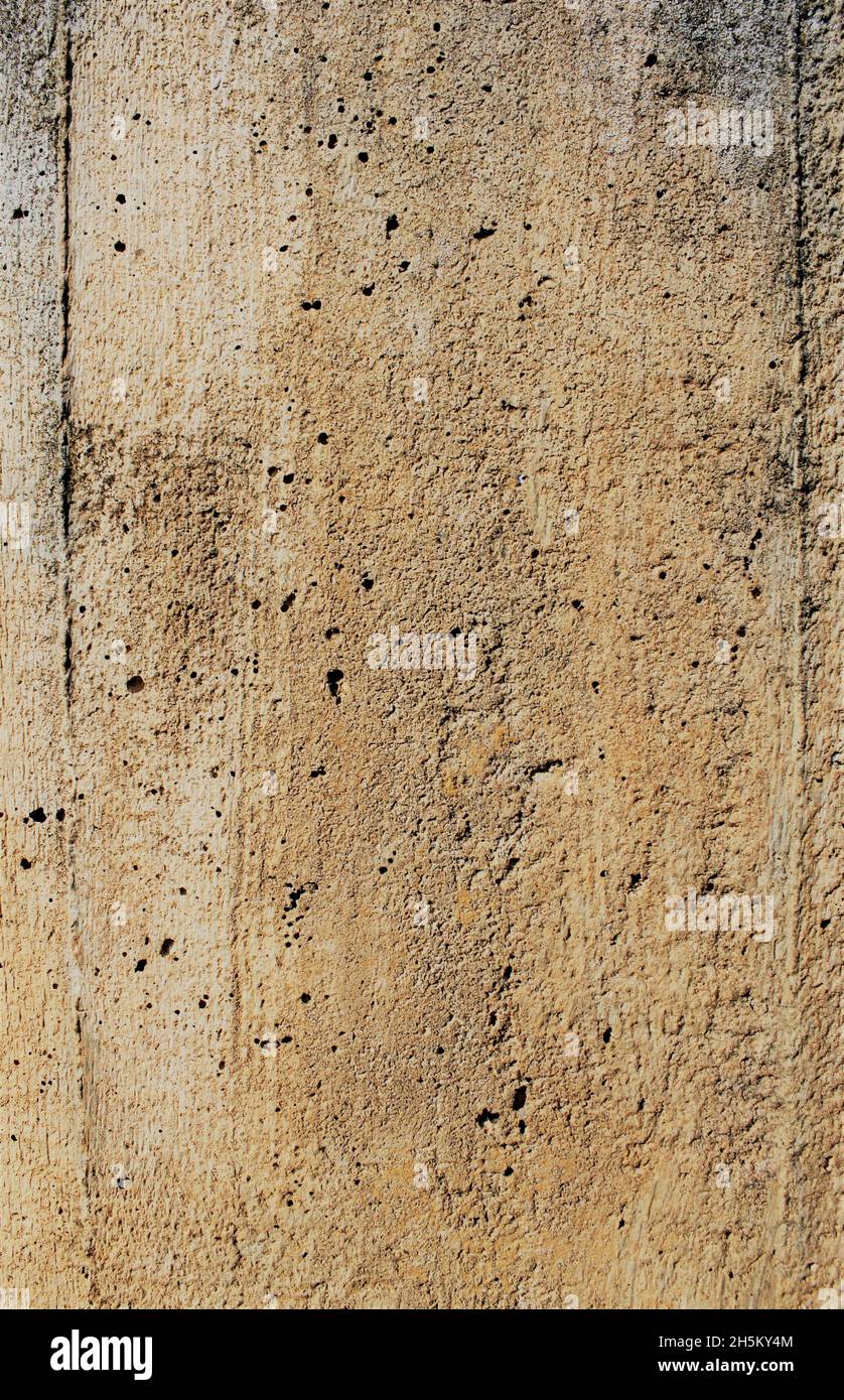 Old gray brown irregular concrete wall as background Stock Photo