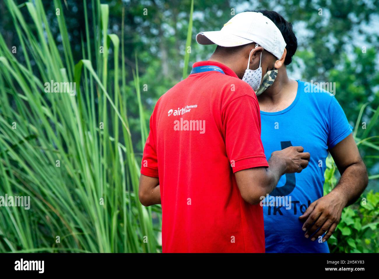 Man wearing the red shirt of airtel payments bank the digital wallet and  cashless solution, with another person wearing a tik tok shirt Stock Photo  - Alamy