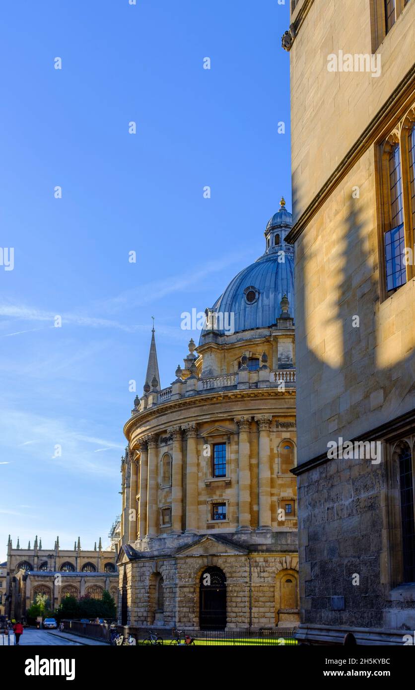 Sun rays aound the side of All Souls college and between the Bodleian Library in Oxford bathed in golden early morning winter light. Stock Photo