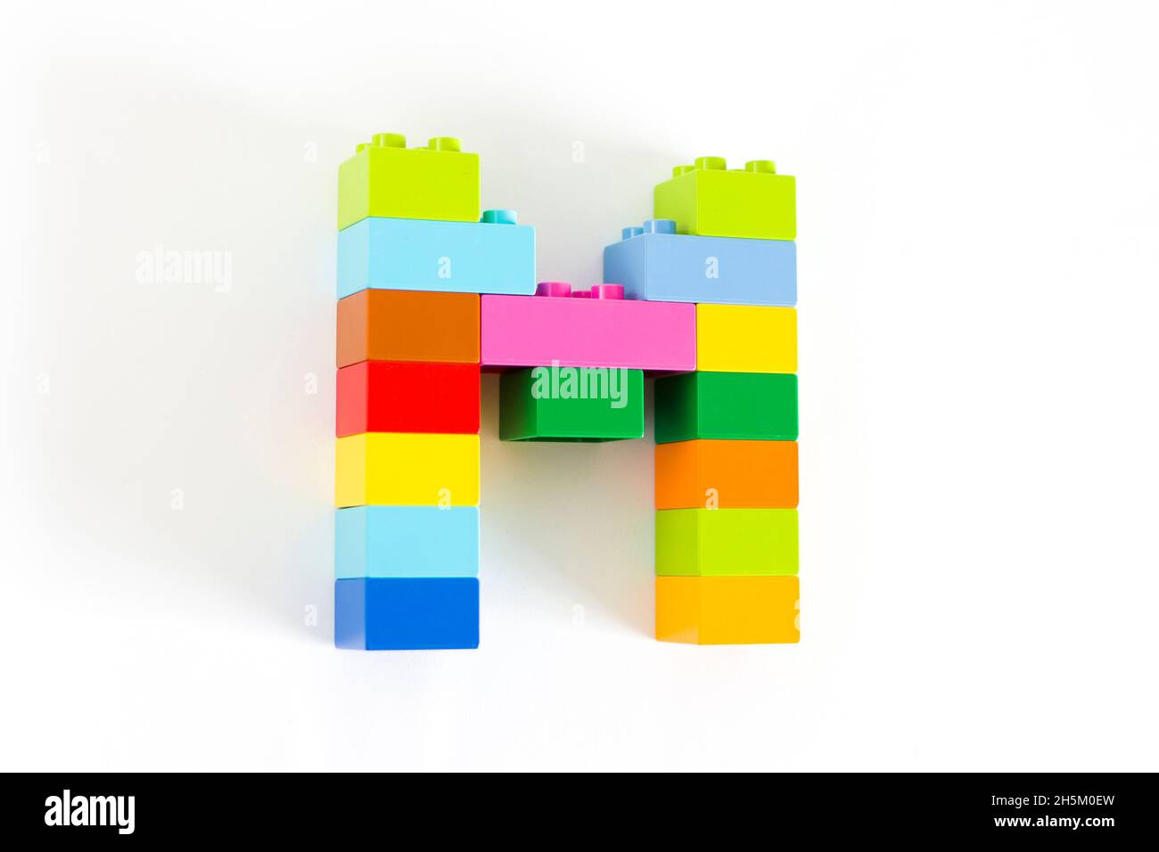 Colorful toy brick letter M isolated on the white background Stock