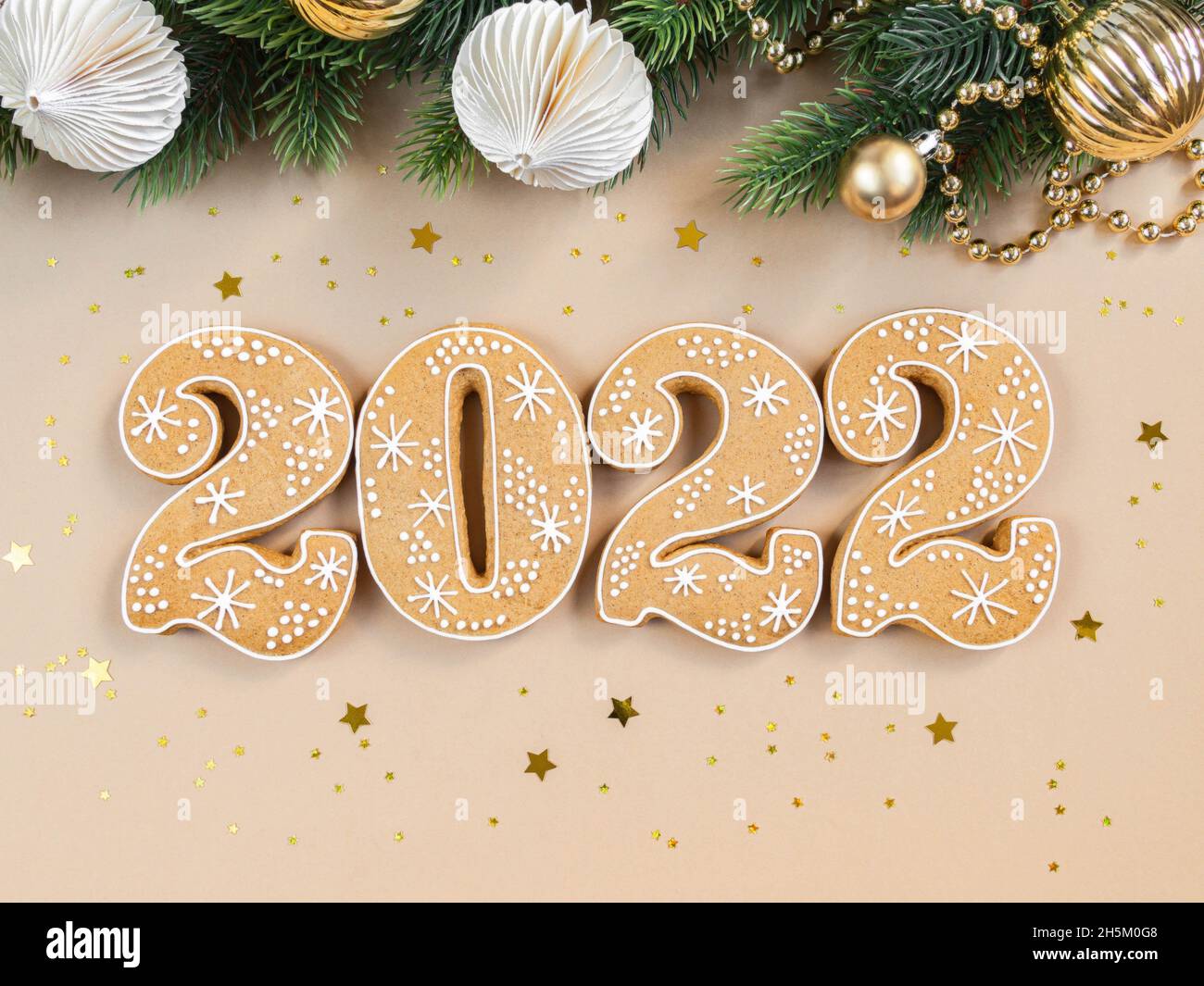 Gingerbread cookies in the form of numbers, gingerbread New Year 2022 and season festive decor on beige background . Top view. Flat lay Stock Photo