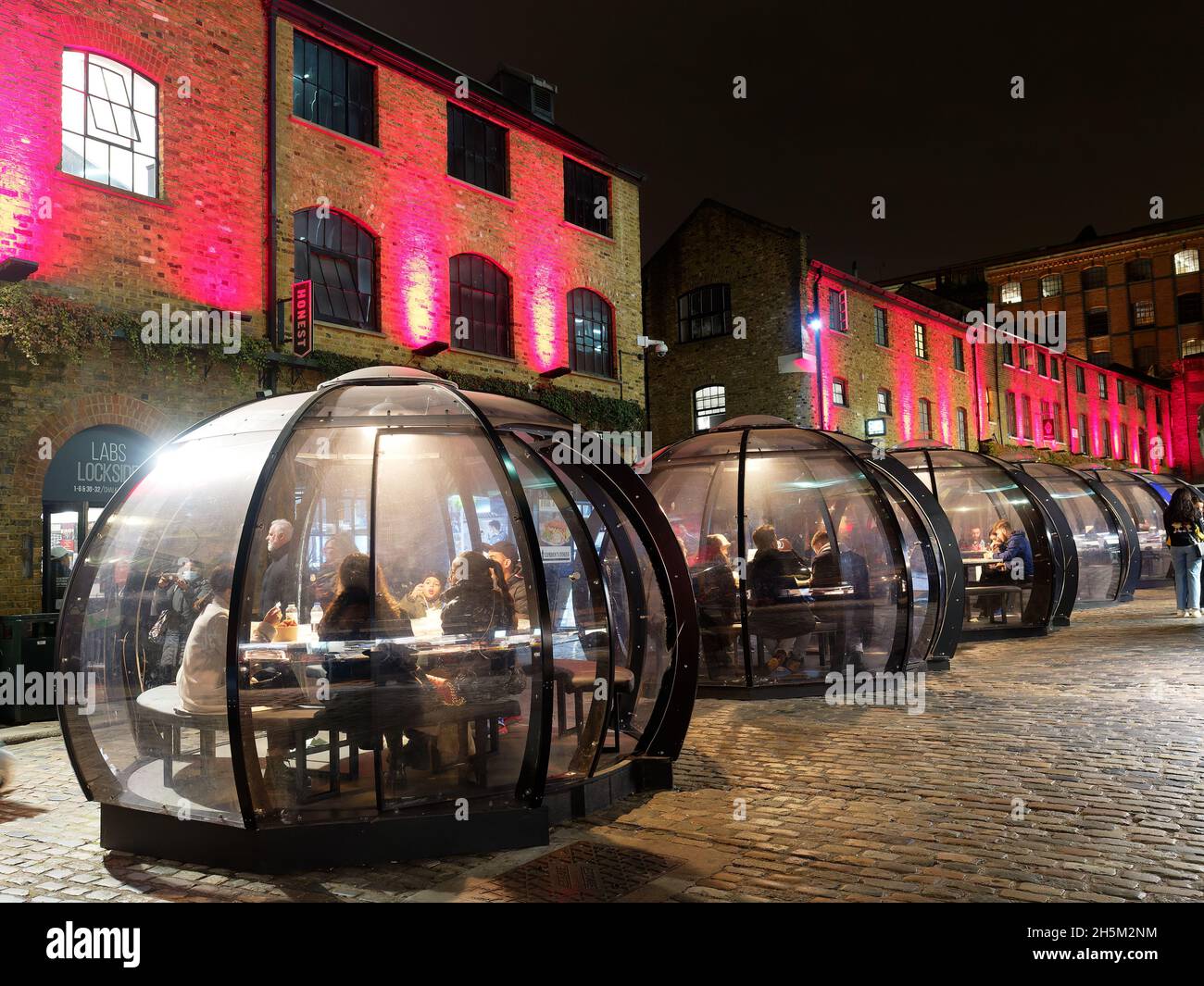 View at night of diners eating in the dining igloos in Camden Market in London Stock Photo