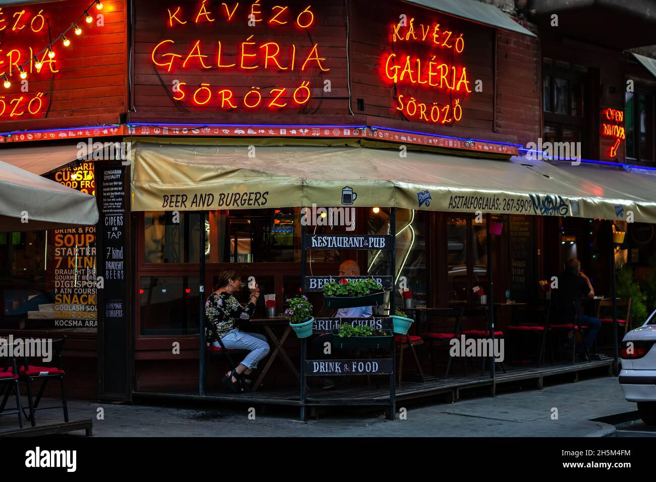 Budapest, Hungary, July 1: Tourists relax in a cafe bar on the street of the evening city of Budapest on July 1, 2018. Stock Photo