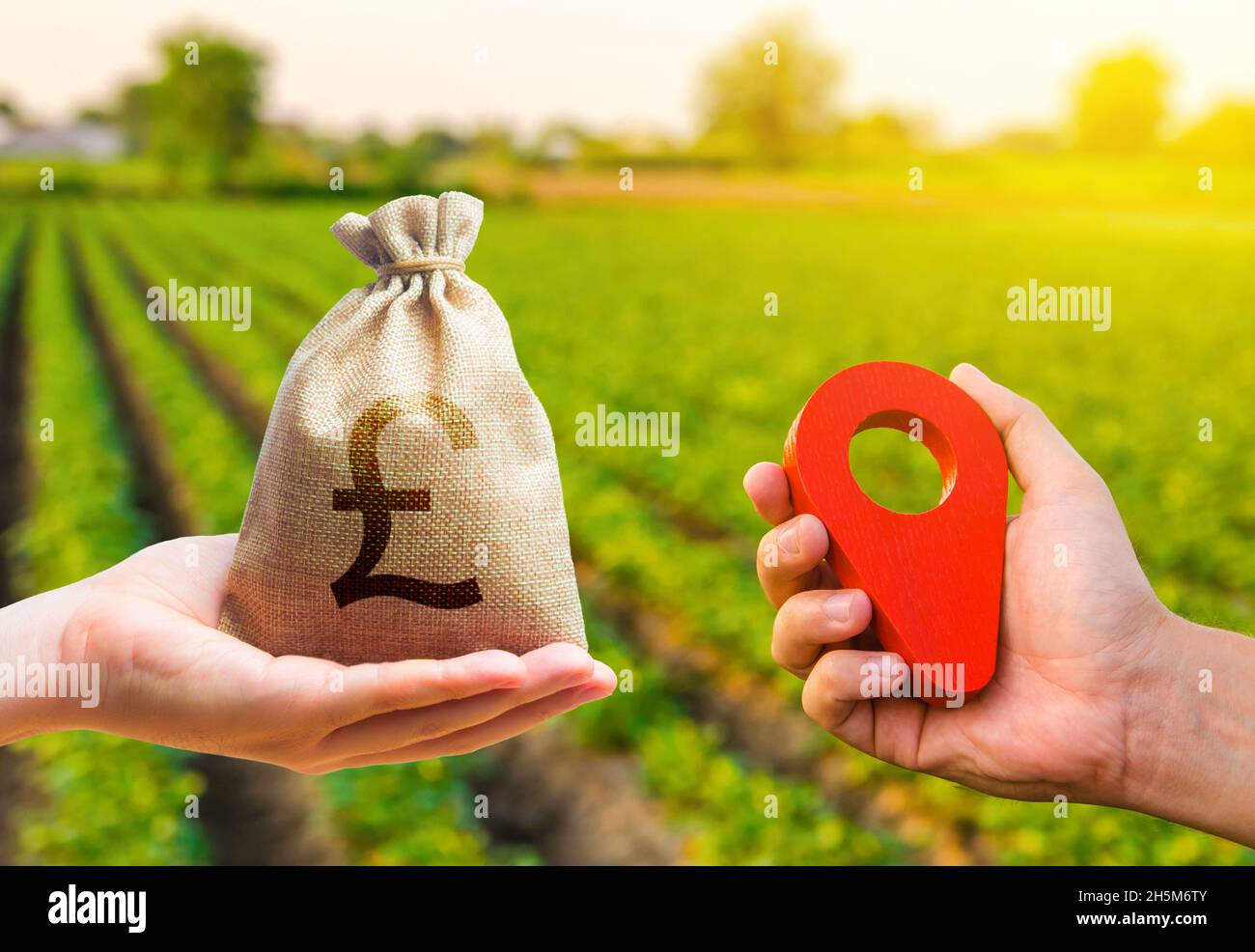 Hands with location pin and british pound sterling money bag. Land market. Estimation cost of plots. Agriculture agribusiness. Buying and selling land Stock Photo