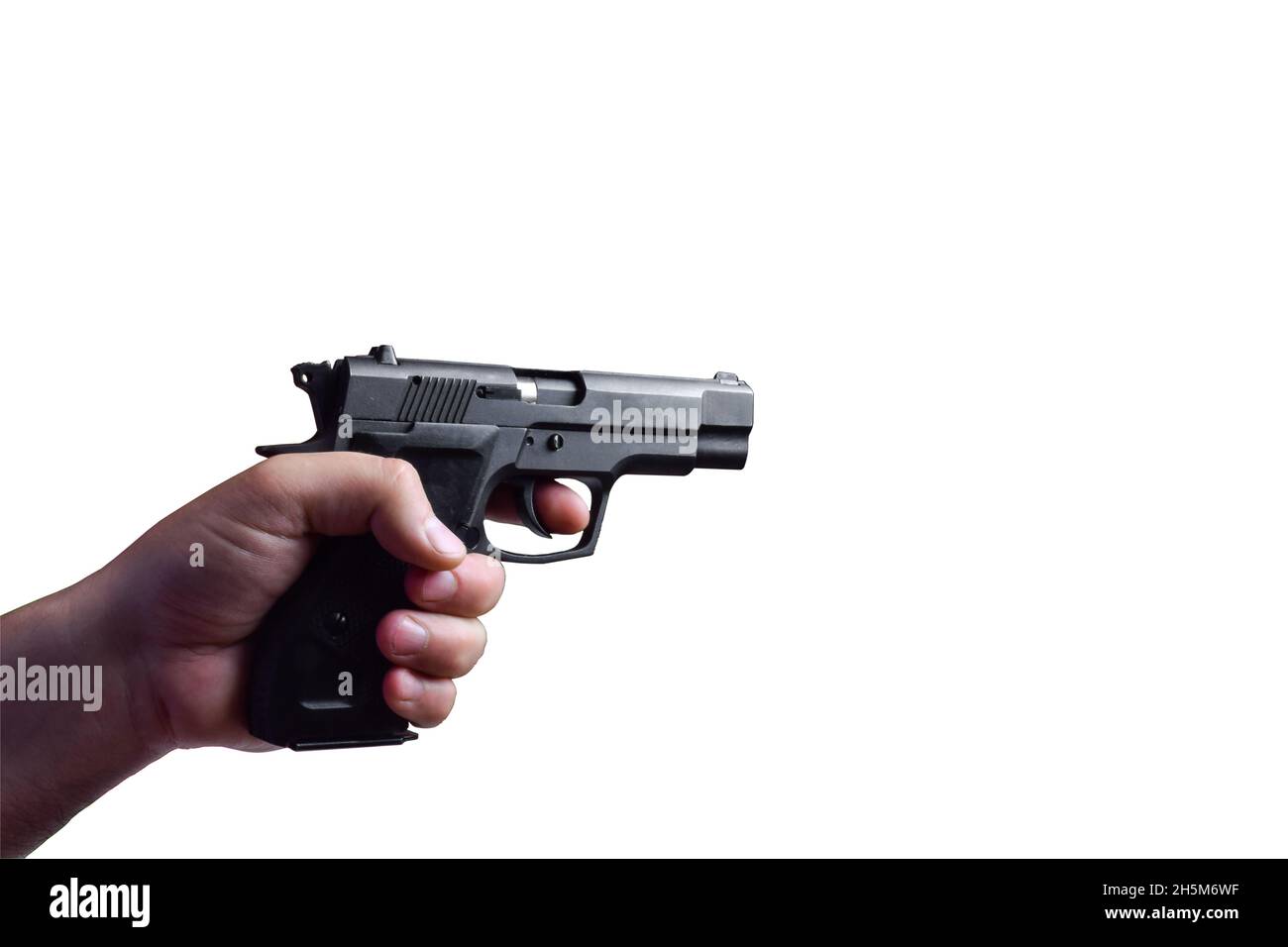 A man's hand holding a horizontal combat black pistol on a white background under clipping. The pistol is aimed at a conventional target Stock Photo