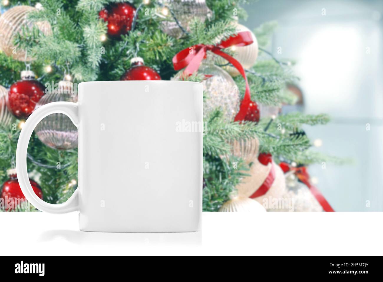 Mug mock up with bright Christmas tree decoration background Stock Photo