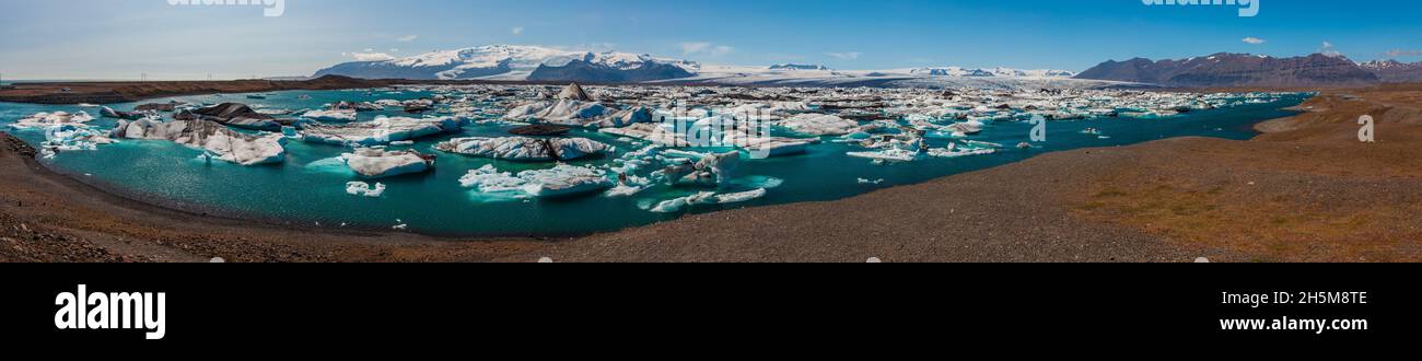 Panorama of The Iceberg Lagoon, Jokulsarlon, Iceland filled with glacial Icebergs with the Vatnajokull Glacier in the background, Europe's biggest gla Stock Photo