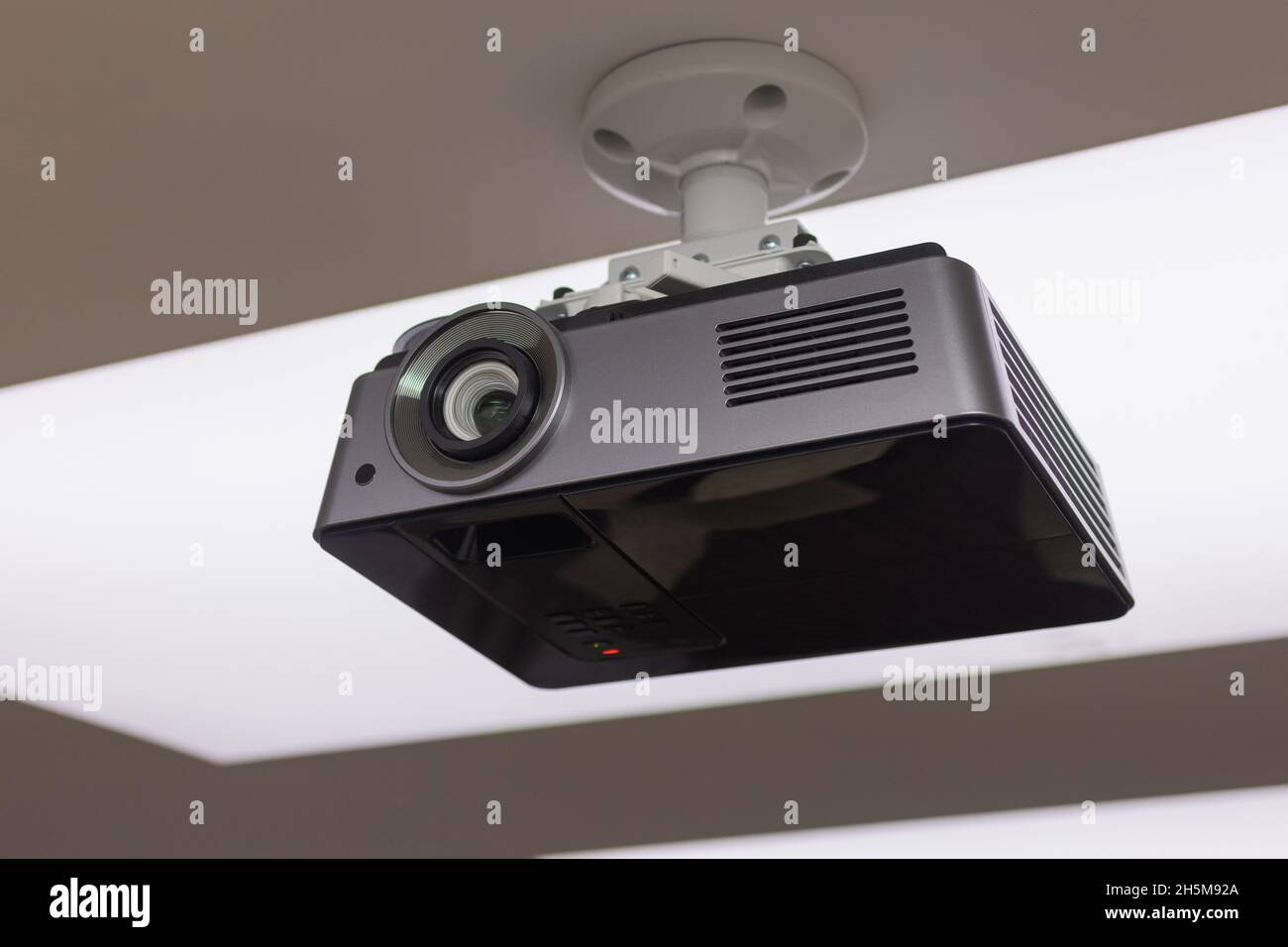 A black overhead projector on ceiling in a conference room modern