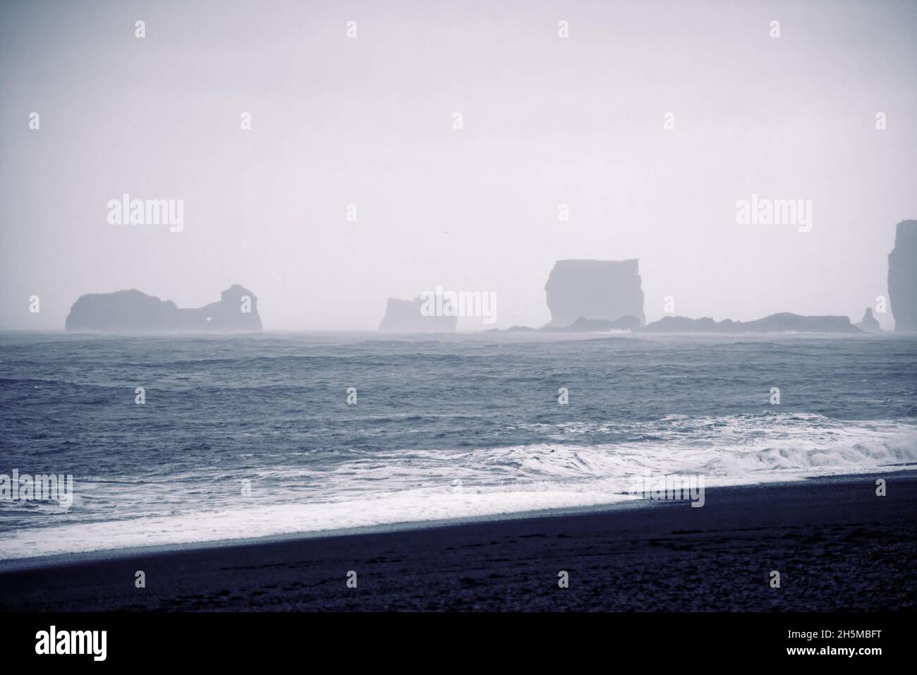 The Reynisdrangar basalt sea stacks and the Reynisfjara black sand ...