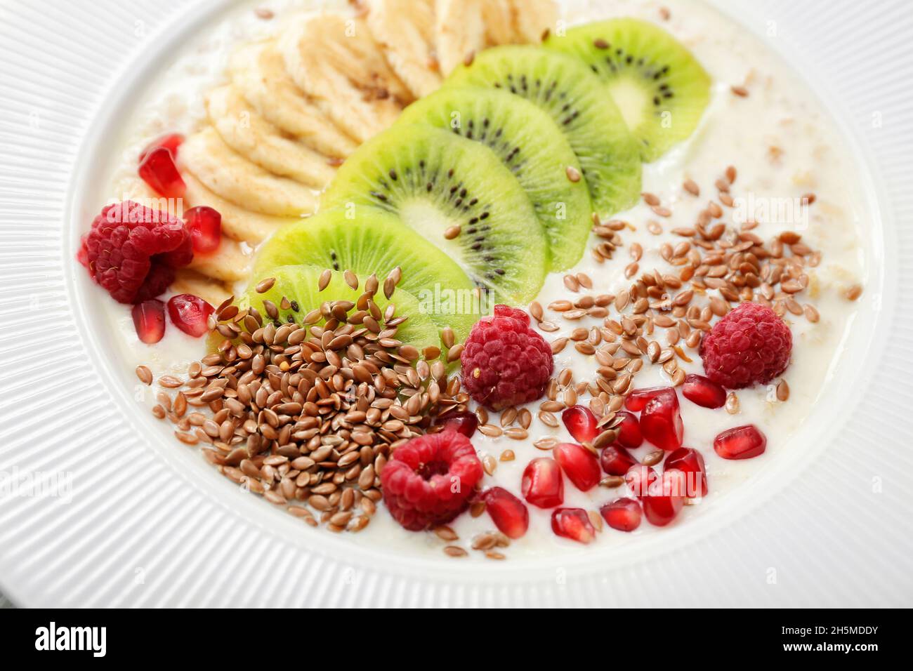 Tasty yoghurt with fruits and flax seeds in bowl, closeup Stock Photo