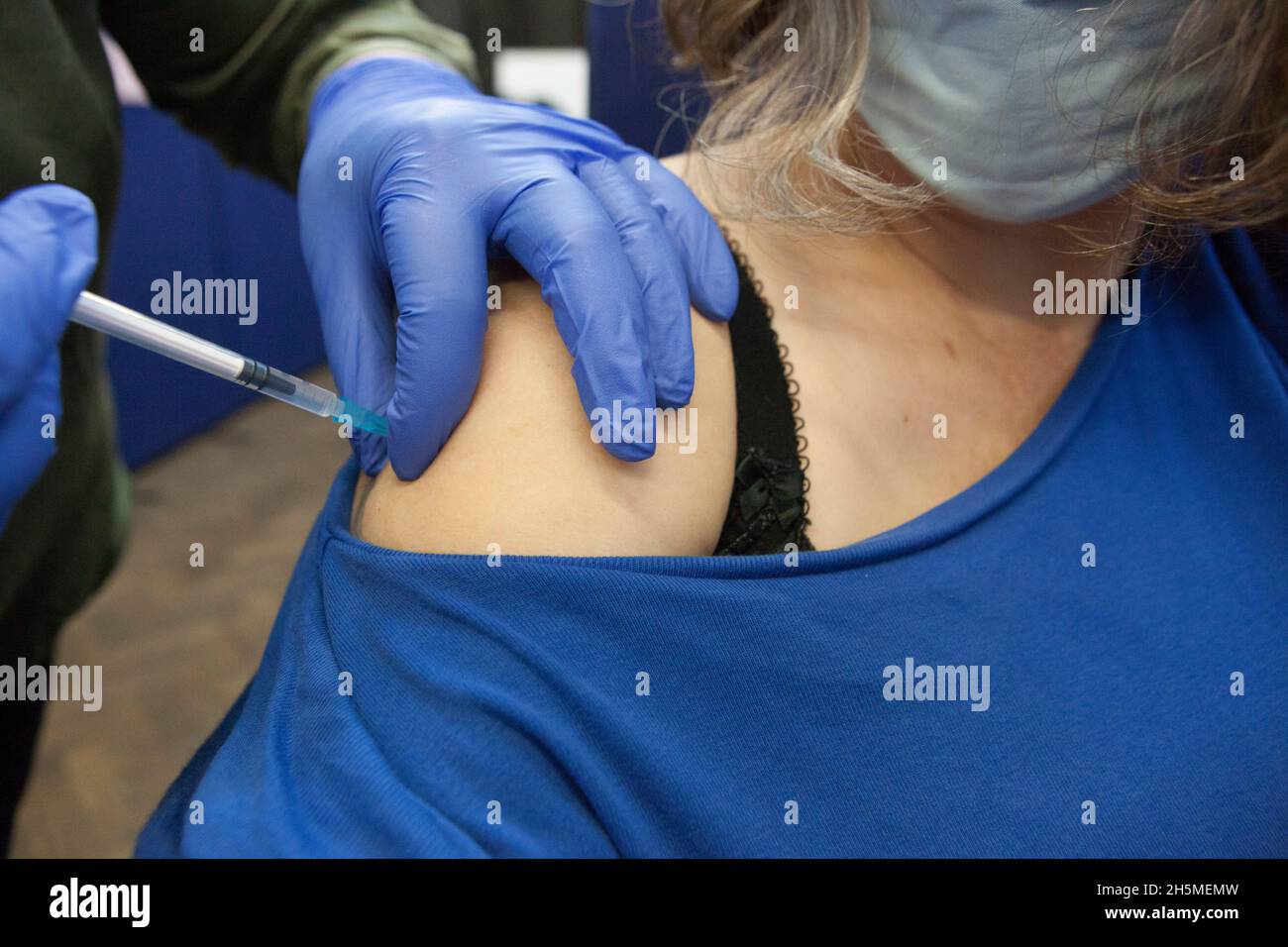 London, UK, 10 November 2021: at a vaccination centre next to Kennington Oval cricket ground a steady stream of people attend to get their booster jabs or first jabs of Pfizer coronavirus vaccine. The photographer receives her booster dose.  Anna Watson/Alamy Live News Stock Photo