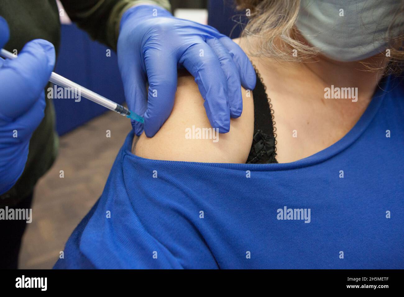 London, UK, 10 November 2021: at a vaccination centre next to Kennington Oval cricket ground a steady stream of people attend to get their booster jabs or first jabs of Pfizer coronavirus vaccine. The photographer receives her booster dose.  Anna Watson/Alamy Live News Stock Photo