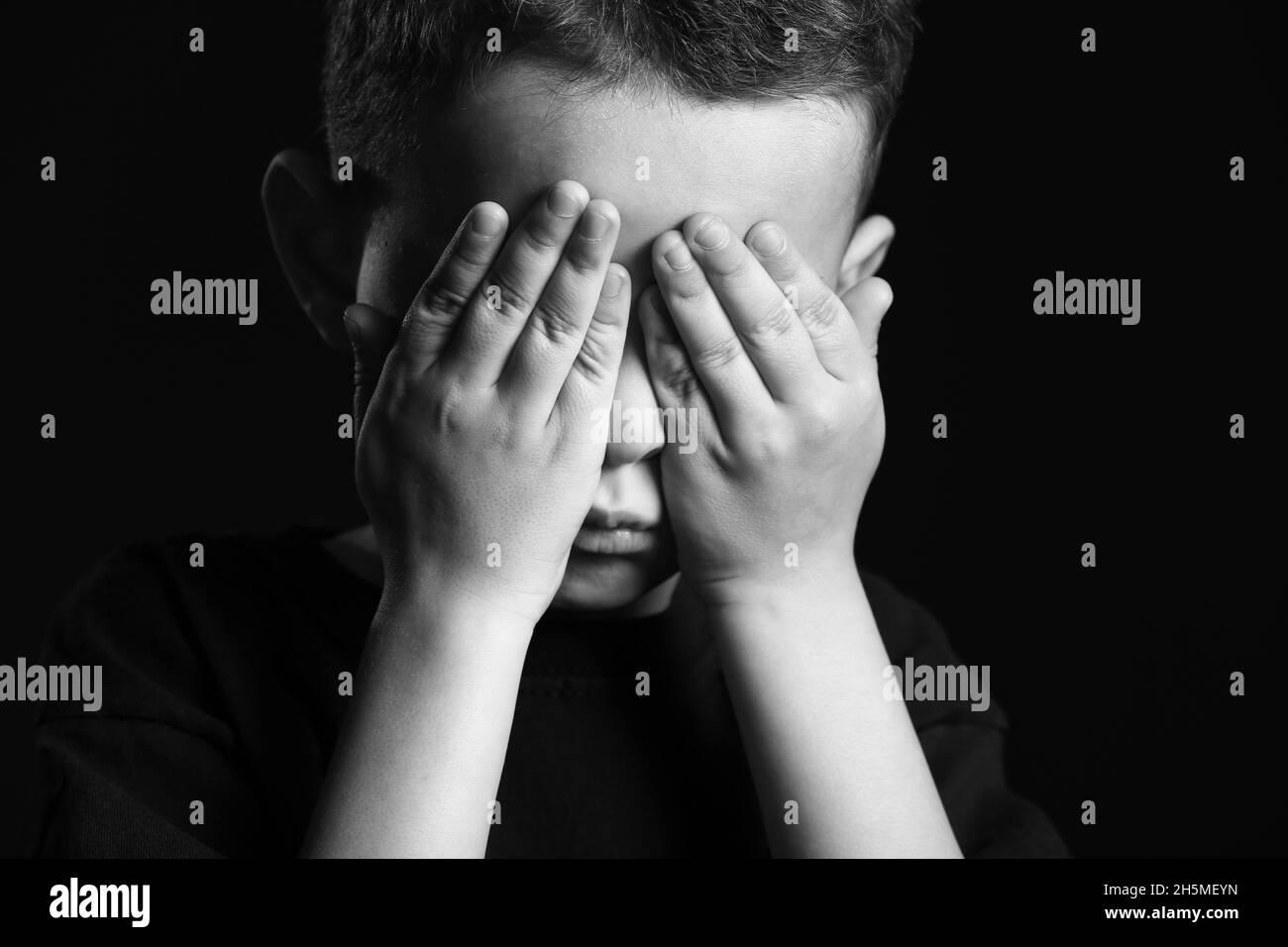 Black and white portrait of cute little boy covering eyes with his ...