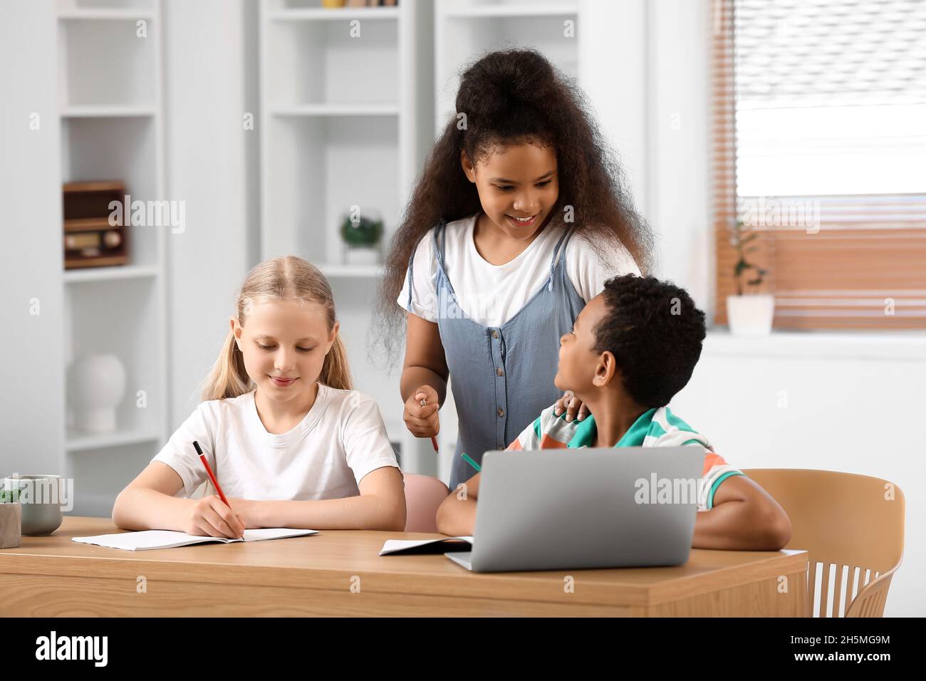 Little schoolchildren studying online at home Stock Photo