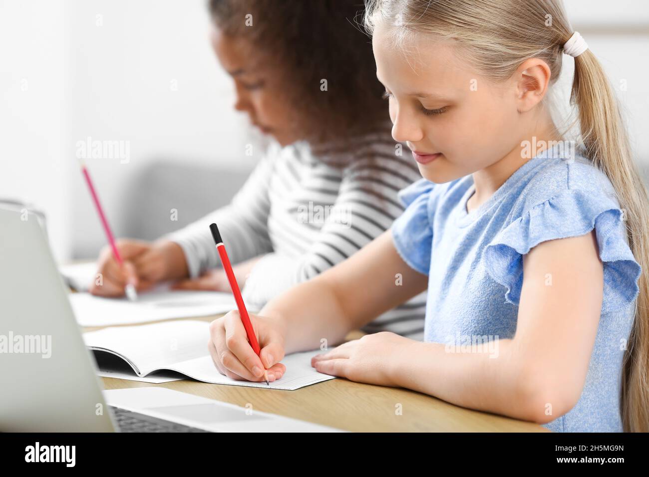 Little pupils studying online at home Stock Photo