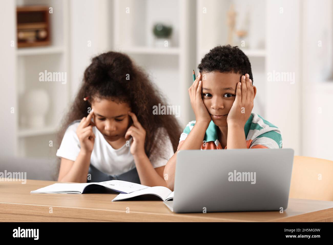 Little schoolchildren studying online at home Stock Photo