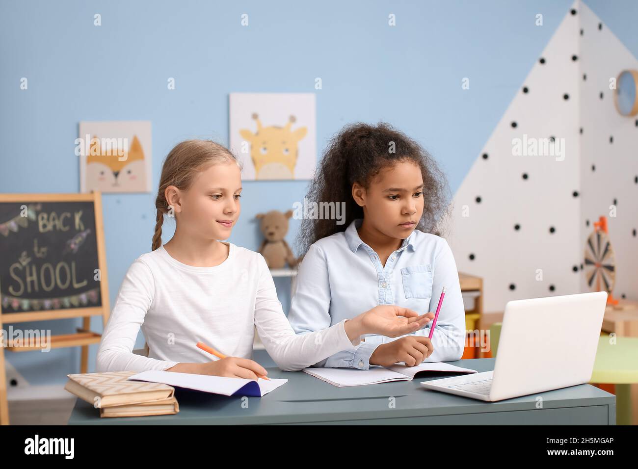 Little pupils studying online at home Stock Photo