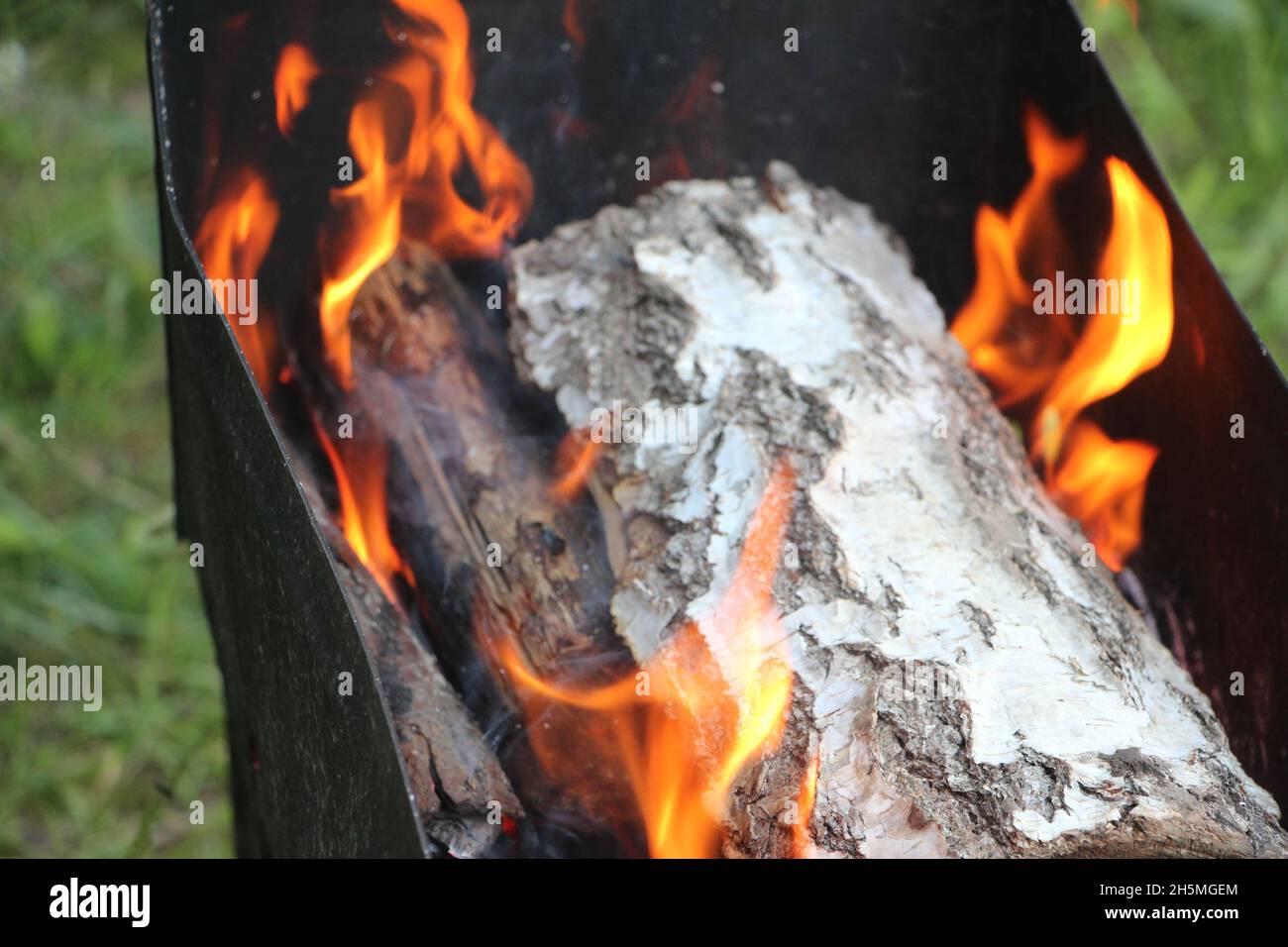 Smoldering ashes of a bonfire. Fire burns closeup at campfire. Stock Photo