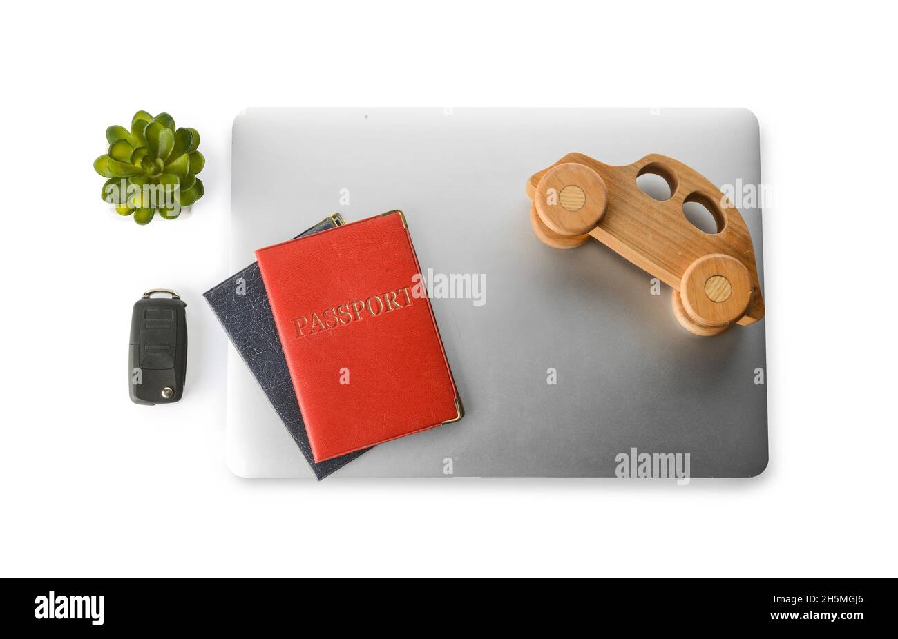 Laptop, toy automobile, passports and key fob on white background. Car