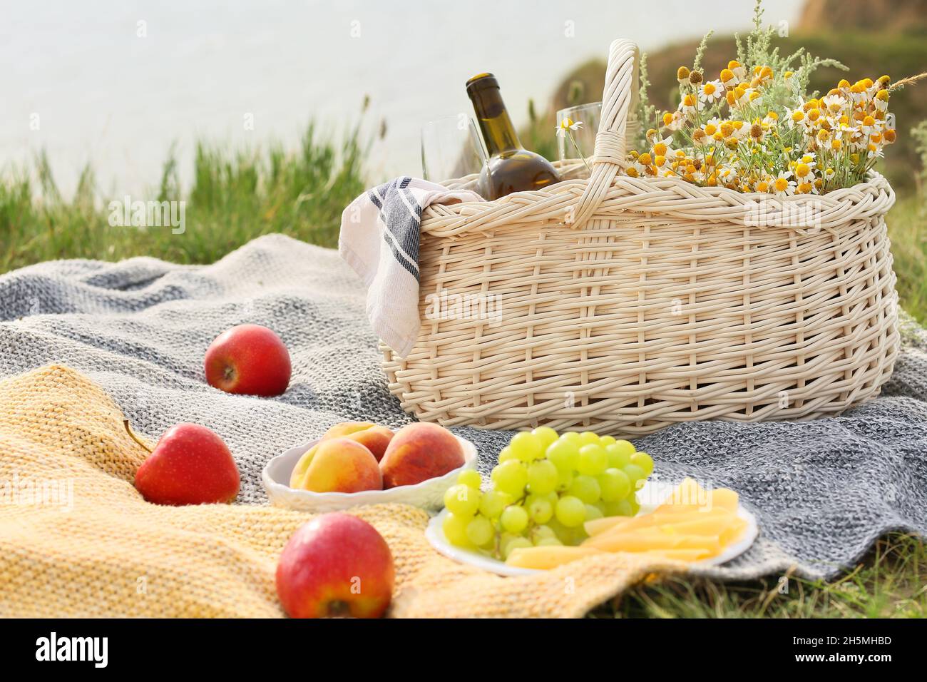 Wicker basket with tasty food and drink for picnic outdoors Stock Photo ...