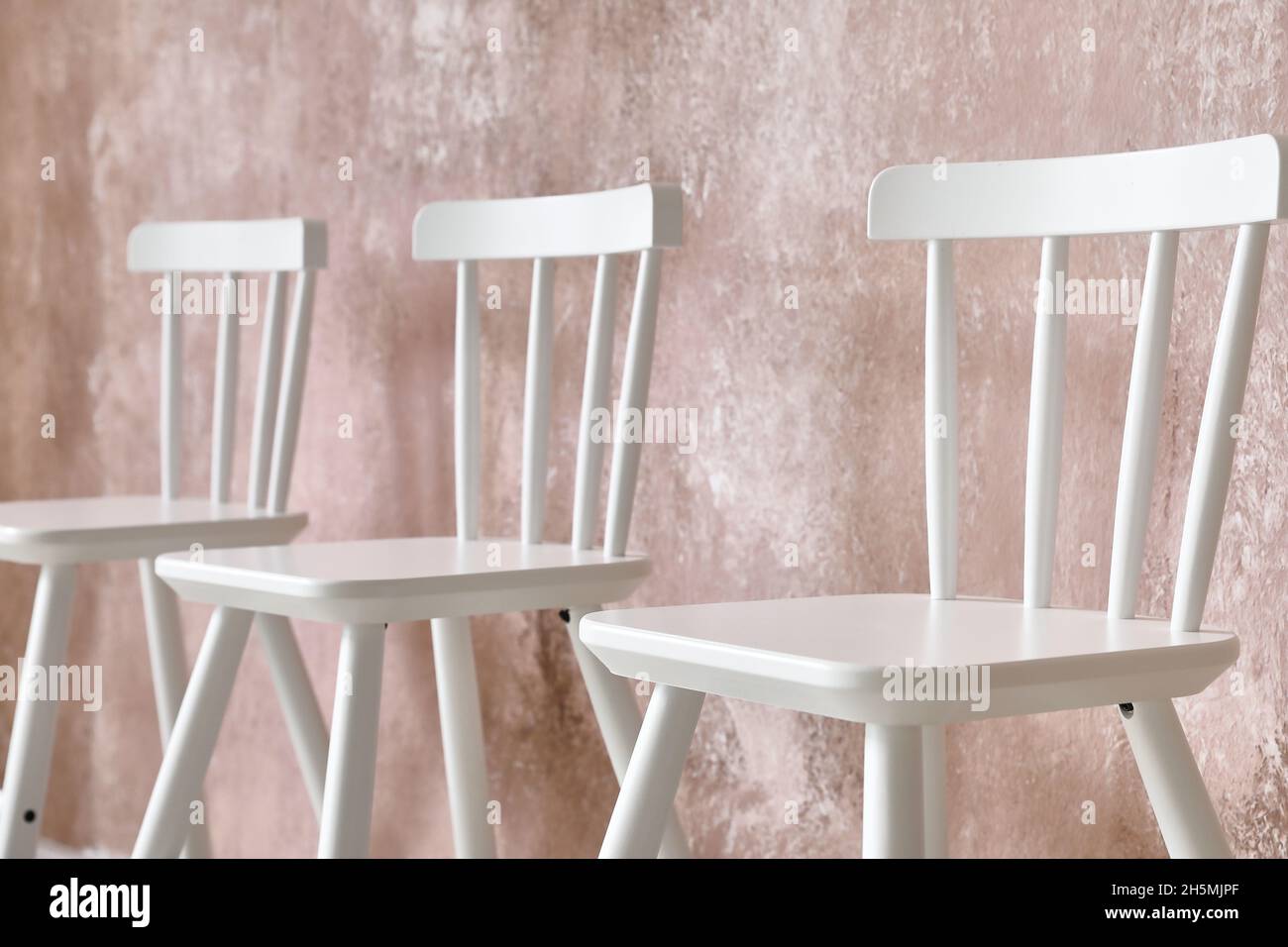 Modern chairs near color wall Stock Photo - Alamy