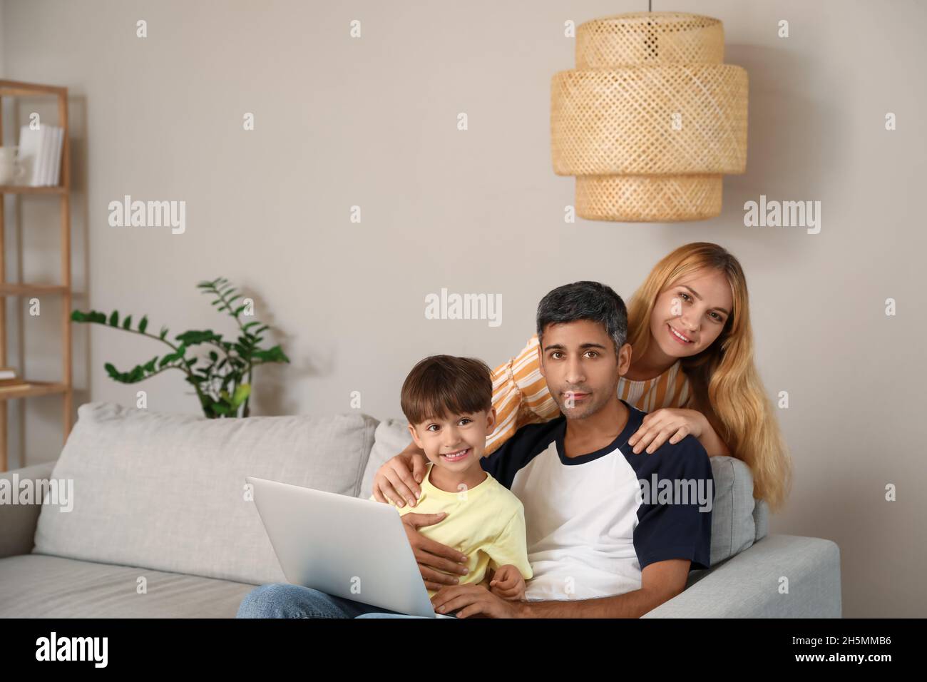 Little boy and his parents using laptop on sofa at home Stock Photo - Alamy