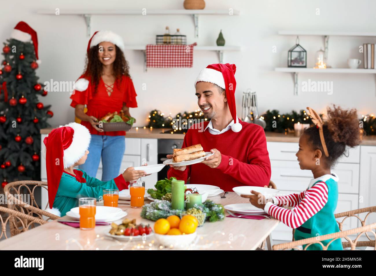 Mother setting table for Christmas dinner with her family in kitchen ...