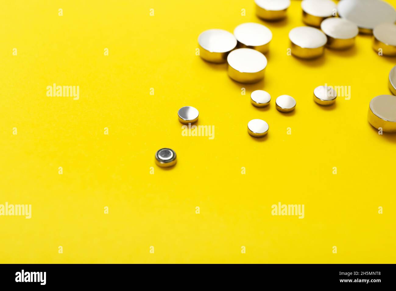 Yellow Button Cell Lithium button cell batteries on yellow background, closeup Stock Photo ...