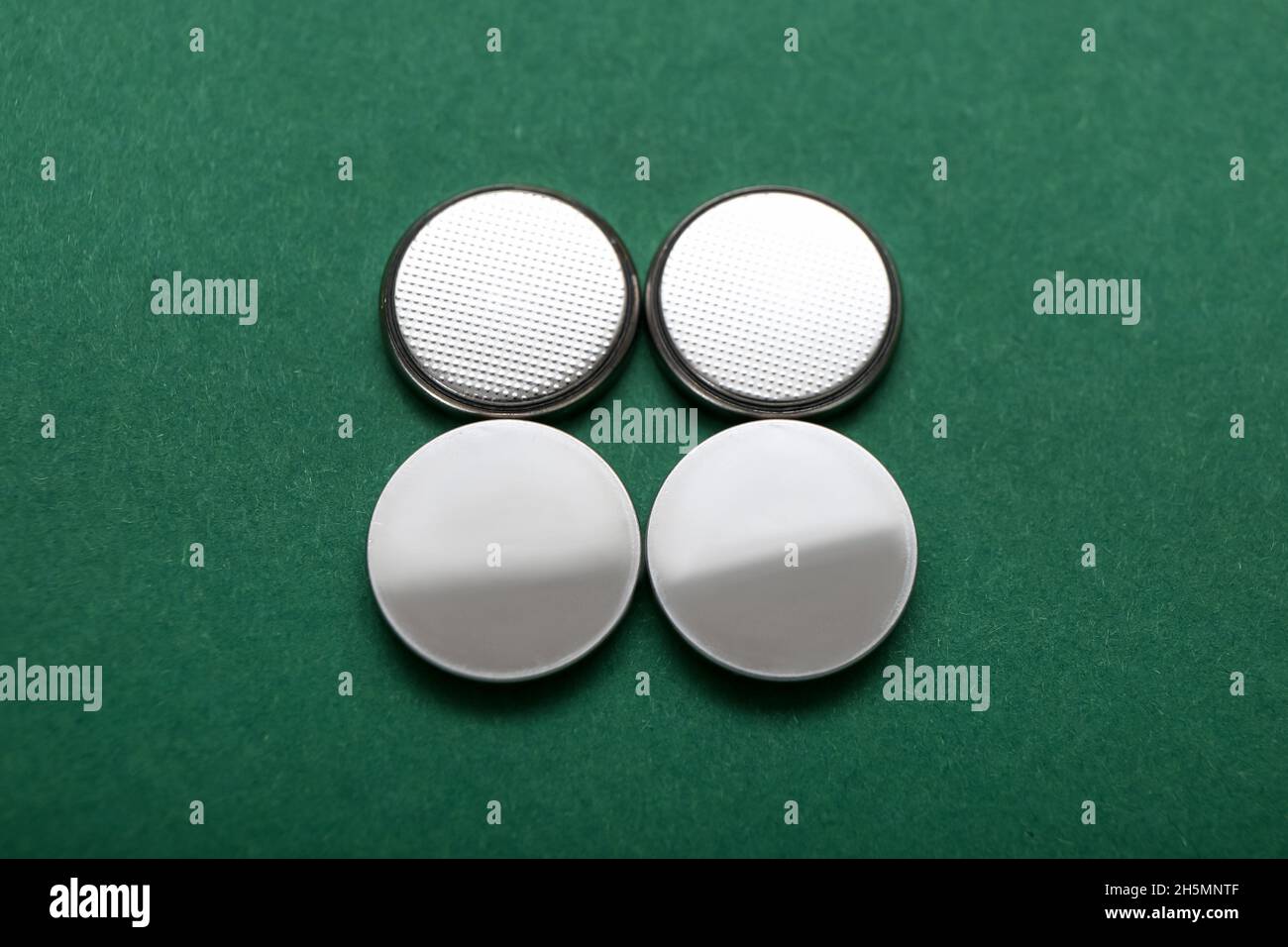Lithium button cell batteries on green background Stock Photo