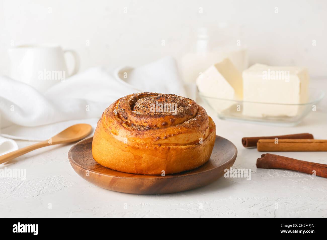 Plate of tasty cinnamon roll on white background Stock Photo - Alamy
