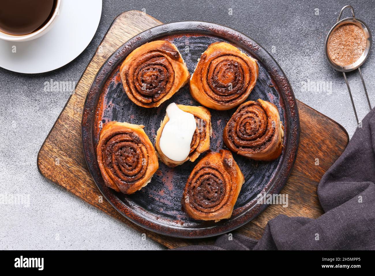 Plate with tasty cinnamon rolls on black and white background Stock ...