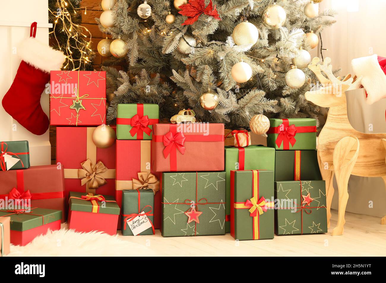 Beautiful gift boxes under Christmas tree in room Stock Photo Alamy