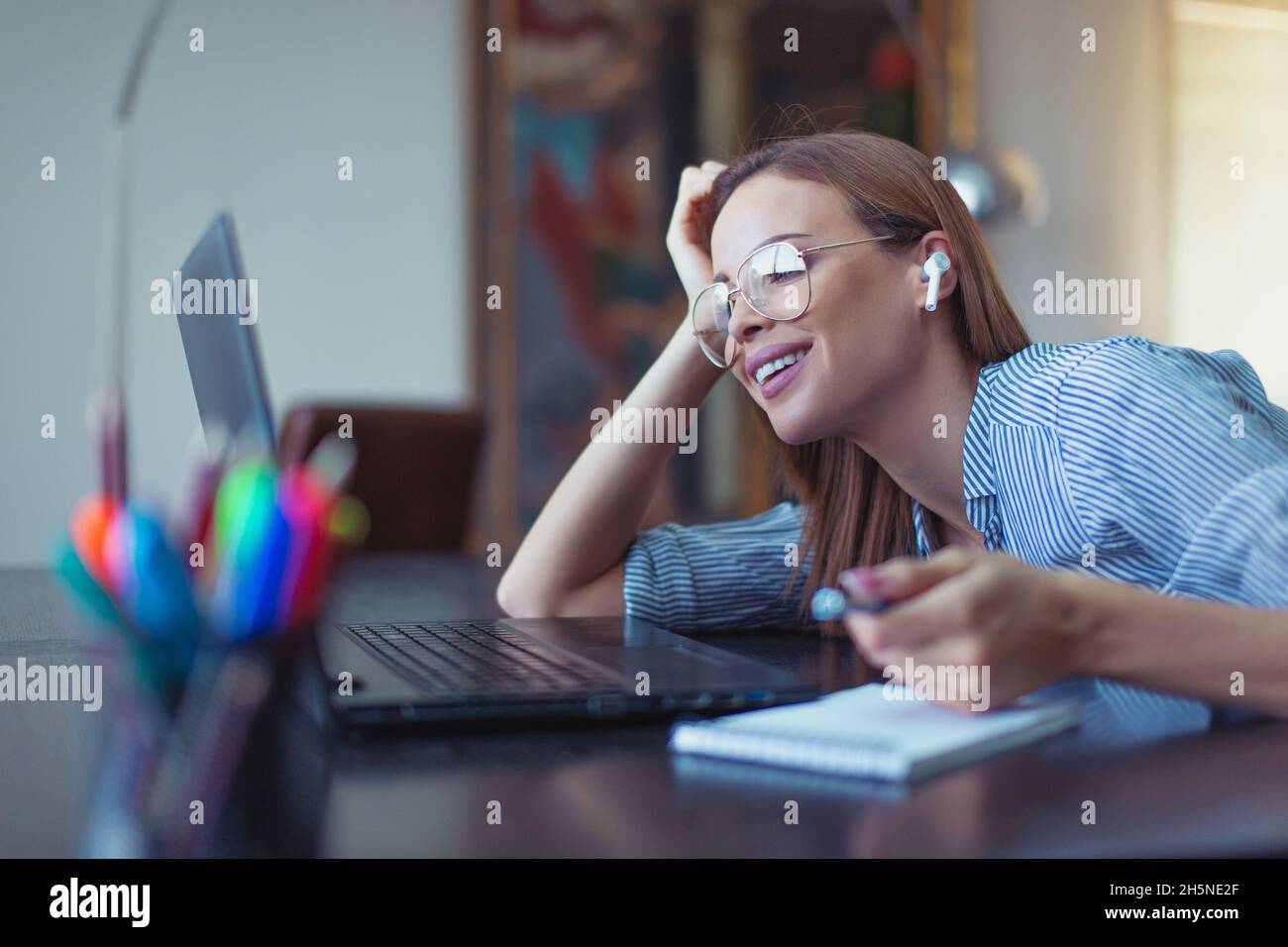 Happy positive Caucasian businesswoman laughing during online communication at laptop Stock Photo