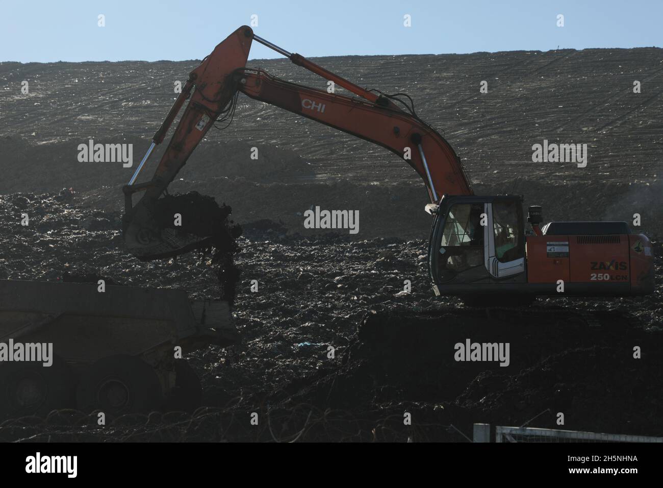 An excavator seen at the Hrybovytchi landfill which is under reclamation (artificial restoration of soil fertility and vegetation after man-made disturbance of nature). The only legal place for garbage collection from Lviv and surrounding villages. It has been operating since 1958 close to the village of Velyki Hrybovychi. The landfill area is over 38 hectares. On May 28, 2016, a large fire broke out on the territory of the Hrybovytsia landfill causing a collapse of solid waste where three rescuers died under the rubble. Stock Photo
