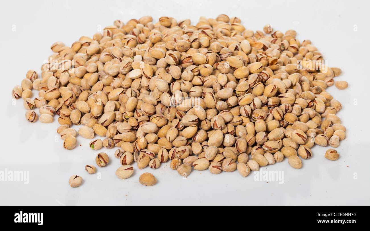 Pile of unshelled pistachios on white Stock Photo Alamy