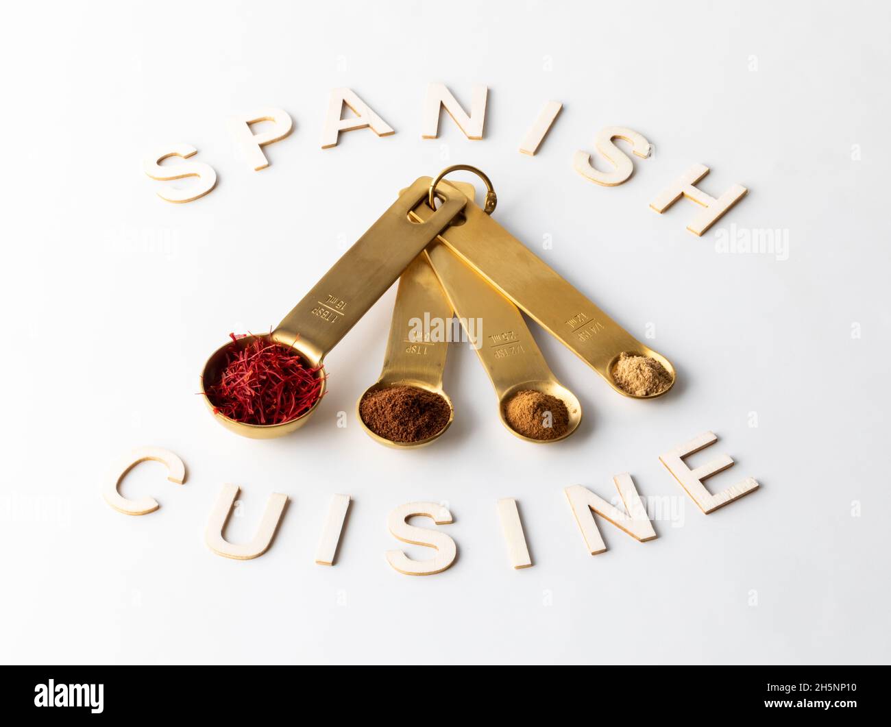 Measuring spoons filled with various spices used in Spanish cooking