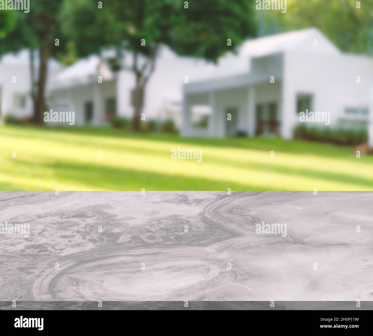 Blank space of marble table for product presentation, little shiny surface, perspective view with the background of blurred white houses on a hillside Stock Photo