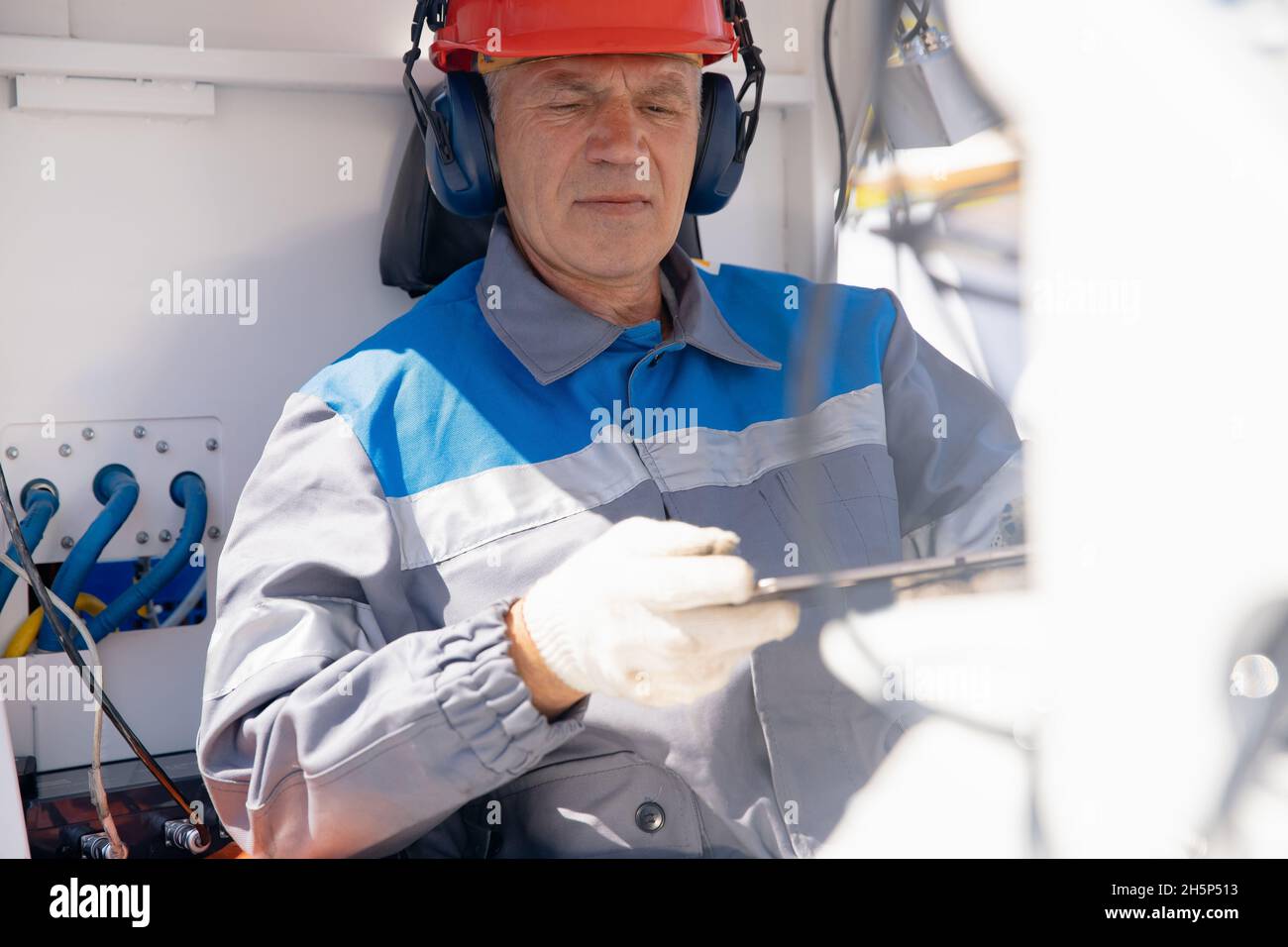Smart manufacturing concept, engineer uses tablet computer to control construction online. Stock Photo