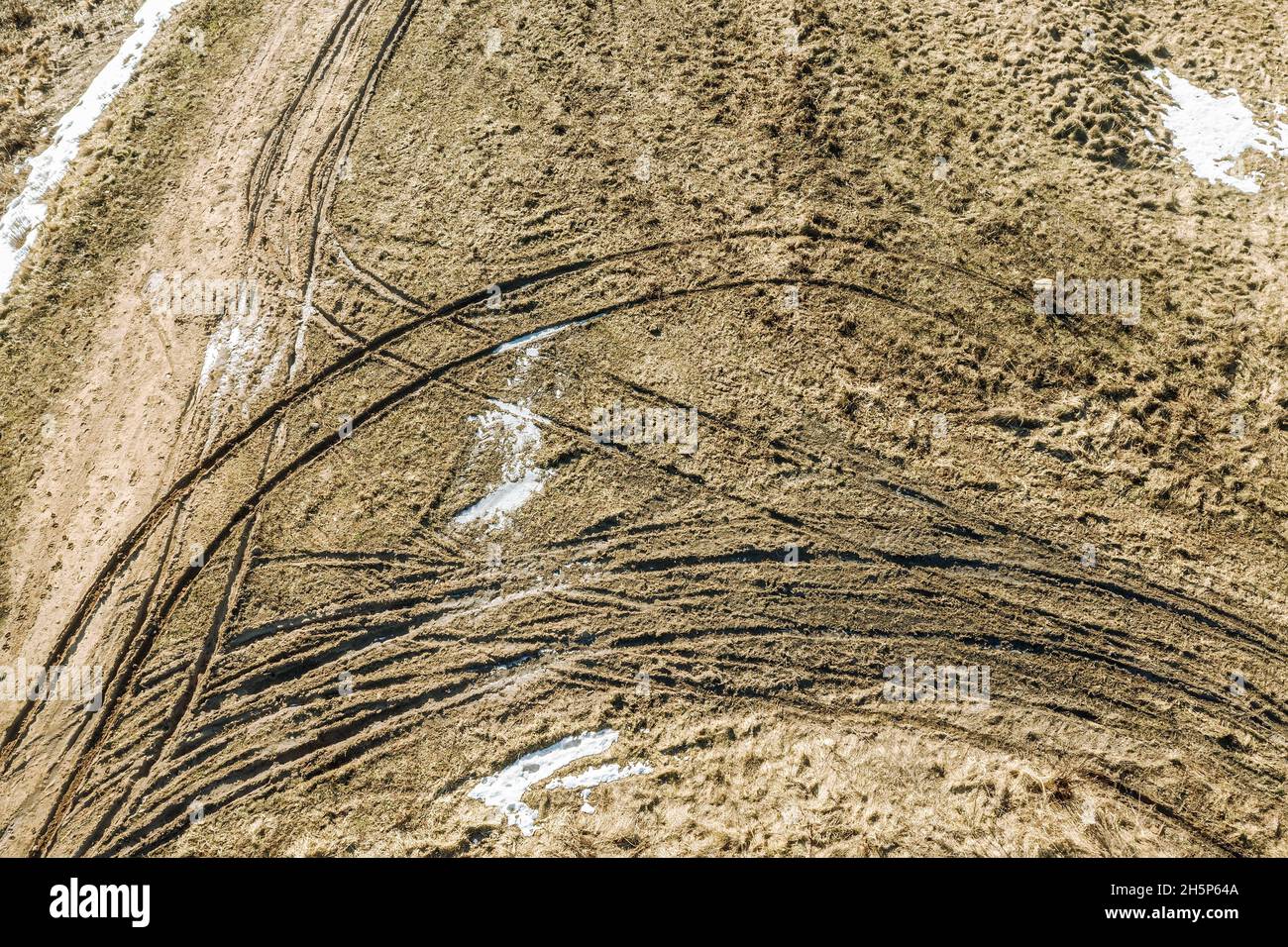 countryside landscape on a sunny cold winter day with tyre traces on the ground. aerial overhead view. Stock Photo