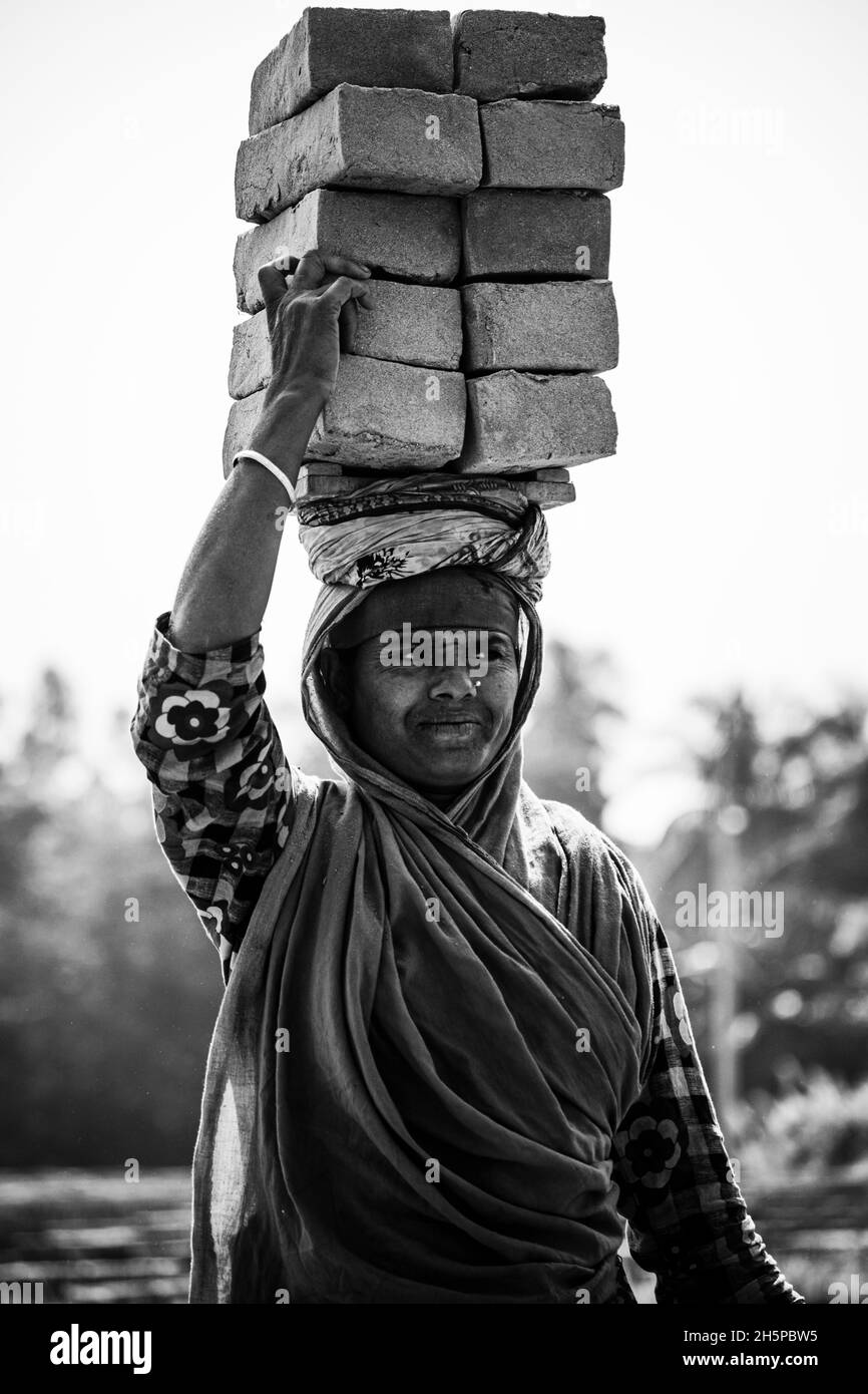 Hardworking woman. She works in the brickfield. This is her only thing to do for a livelihood. Stock Photo