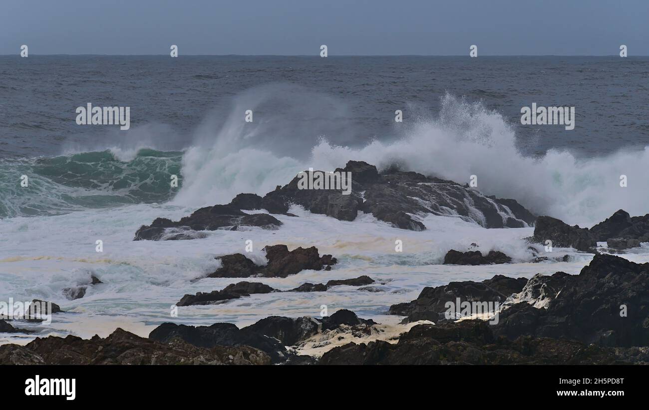 Strong waves breaking on the rocky coast of Vancouver Island viewed from Wild Pacific Trail in Ucluelet, British Columbia, Canada with foam in water. Stock Photo