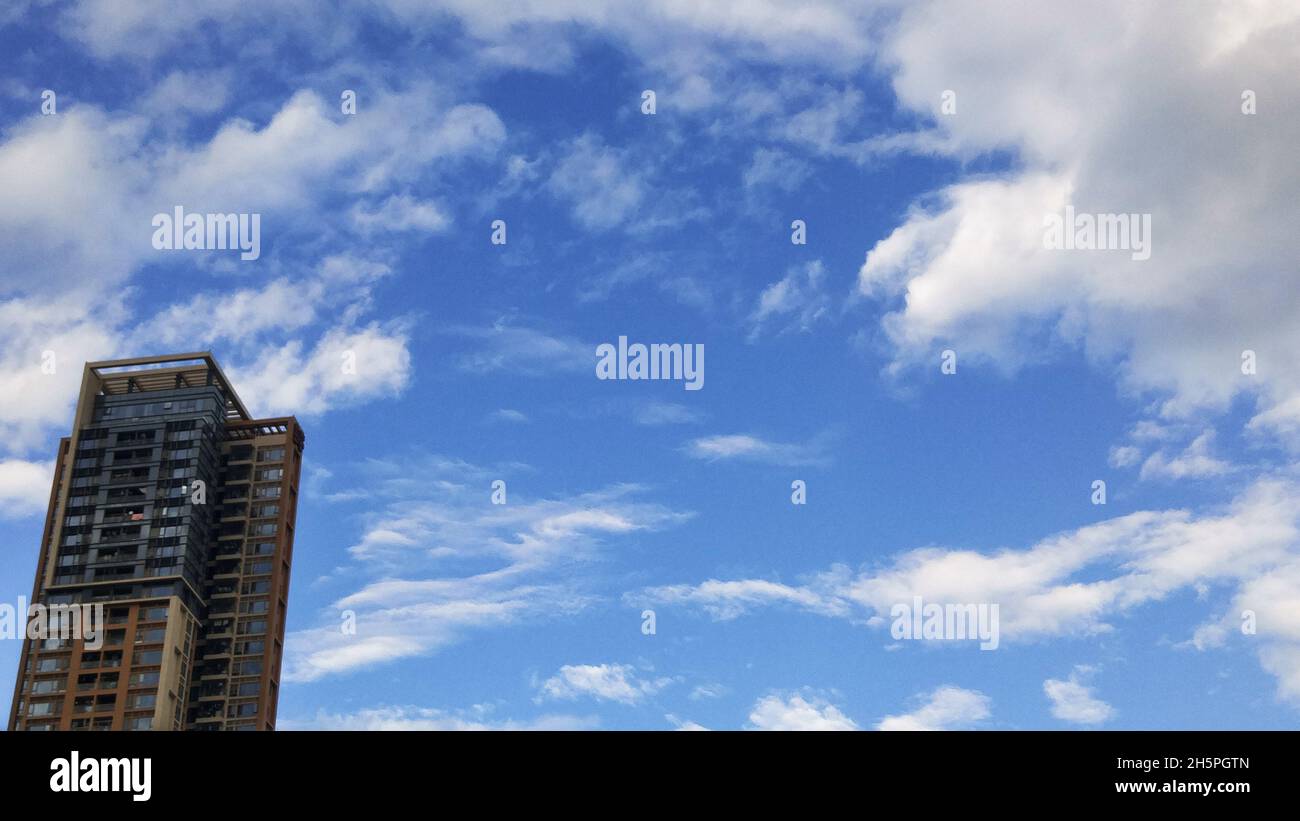 Residential buildings under blue sky and white clouds Stock Photo - Alamy