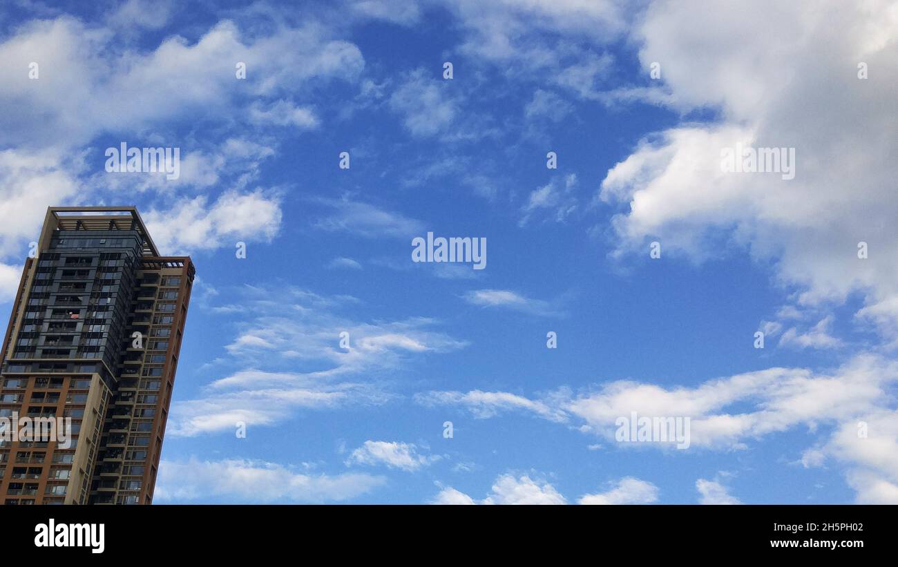 Residential buildings under blue sky and white clouds Stock Photo - Alamy