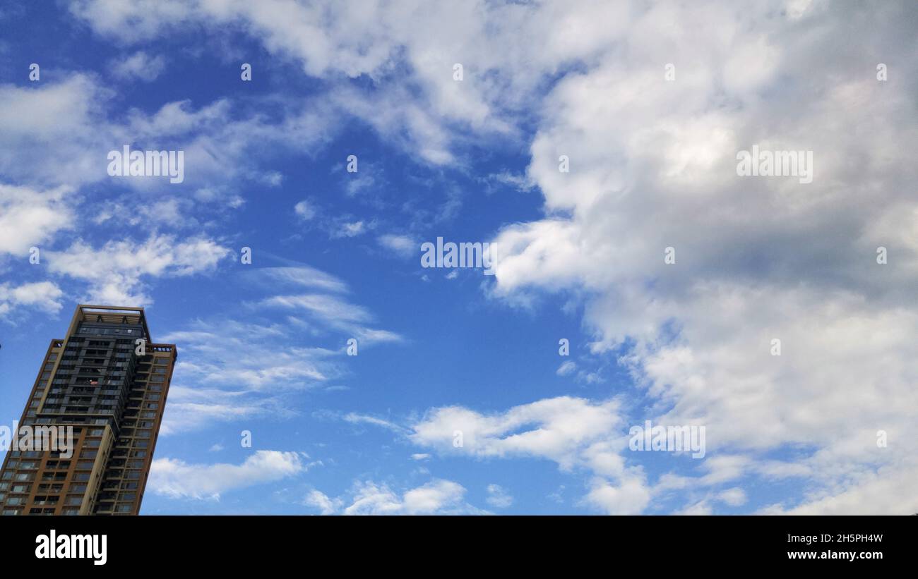 Residential buildings under blue sky and white clouds Stock Photo - Alamy