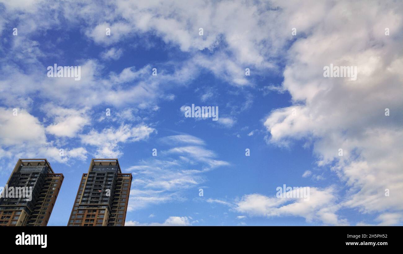 Residential buildings under blue sky and white clouds Stock Photo - Alamy
