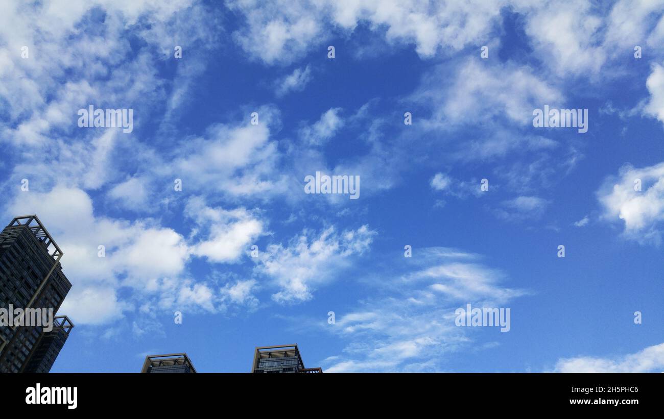 Residential buildings under blue sky and white clouds Stock Photo - Alamy