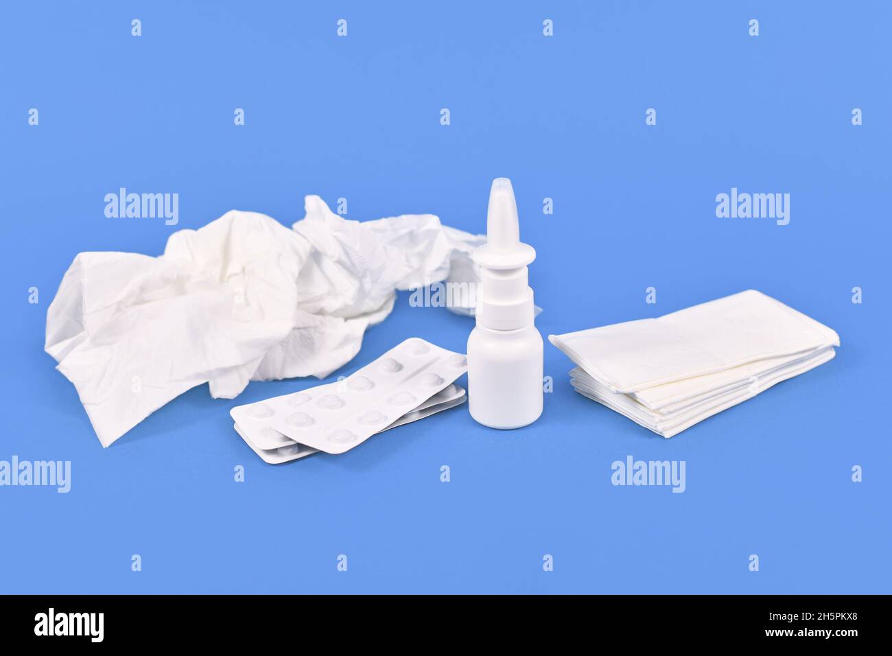 Nasal spray bottle, medicine pills and used tissues used during common