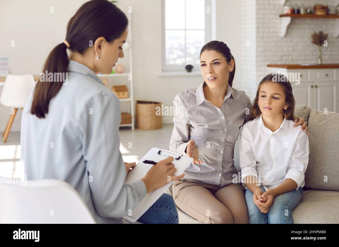 Parent talking to counseling therapist or psychologist about child's behavior problems Stock Photo