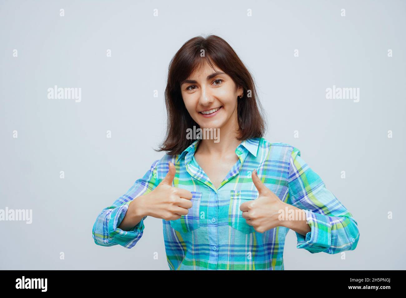 Young caucasian woman success sign doing positive gesture, thumbs up. Isolated on gray background Stock Photo