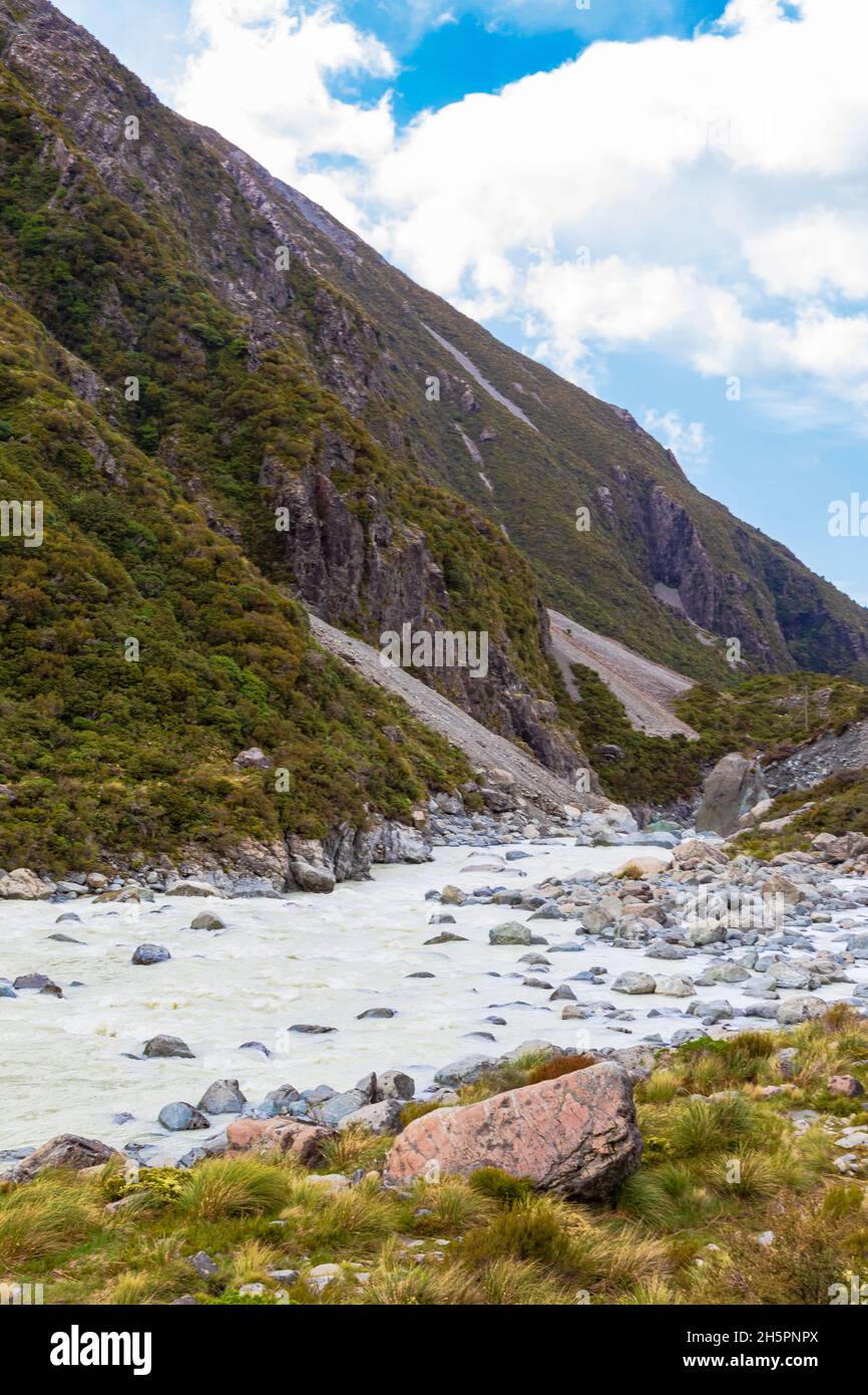 The track among green valley in the Southern Alps in the lake Mueller. South Island, New Zealand. Stock Photo